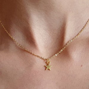 May include: A gold chain necklace with a small gold star pendant.