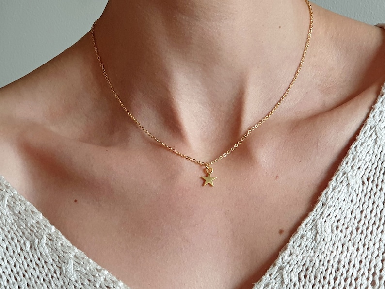 May include: A gold chain necklace with a small gold star pendant.
