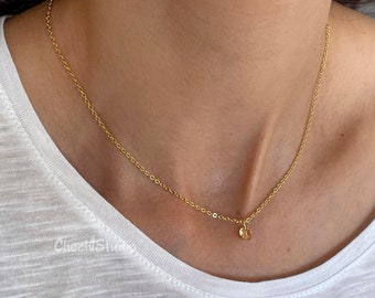 May include: A gold chain necklace with a small, round pendant. The necklace is delicate and simple, making it a perfect everyday accessory.