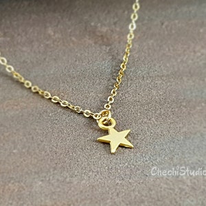 May include: A delicate gold chain necklace with a small gold star pendant.