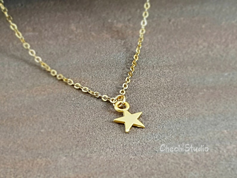 May include: A delicate gold chain necklace with a small gold star pendant.
