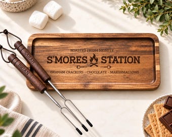 May include: A rectangular wooden serving tray with the engraved text S'MORES STATION, ROASTED FRESH NIGHTLY, and GRAHAM CRACKERS - CHOCOLATE - MARSHMALLOWS. Two metal roasting sticks with dark wooden handles engraved with the names SARAH and BRIAN.