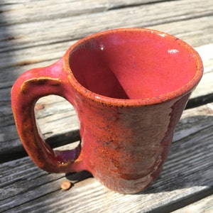 Red mug. Stoneware clay pottery. Wheel thrown. Coffee Cup. Small imperfections.