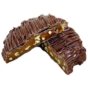 May include: Two pieces of chocolate-covered toffee candy. The toffee is filled with nuts and drizzled with dark chocolate. One piece is cut in half, revealing the interior texture and ingredients.