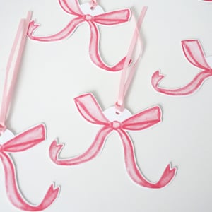 May include: Pink watercolour bow gift tags with white circles and pink ribbon.