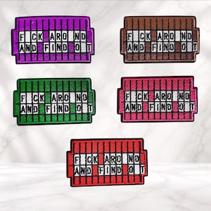 May include: Five rectangular embroidered patches in purple, brown, green, pink, and red. Each patch features a grid design with the text F*CK AROUND AND FIND OUT in white letters across two rows, with black borders and vertical stitching details.