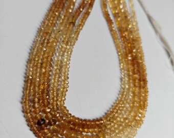 May include: Strands of faceted, golden-yellow gemstone beads. The beads are strung together, creating a layered effect. The color gradient ranges from light yellow to a deeper amber hue. The beads are likely used for jewelry making.