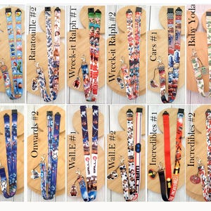 May include: A collection of twelve fabric lanyards featuring various animated movie themes including Toy Story, Ratatouille, Wreck-it Ralph, Cars, Baby Yoda, Onwards, Wall-E, and The Incredibles. Each lanyard includes a metal clasp and a character charm.