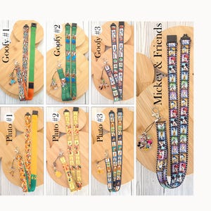 May include: A collection of seven fabric lanyards featuring Disney characters including Goofy, Pluto, Mickey, and friends. Each lanyard includes a metal lobster clasp and a character charm. The designs feature film strip patterns and solid colors.