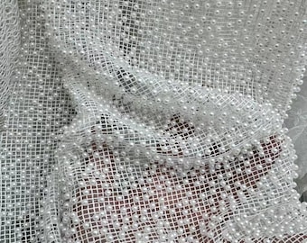 May include: White mesh fabric with small white pearl beads sewn into the fabric in a grid pattern.