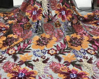 May include: Black mesh fabric with embroidered floral designs in shades of orange, pink, and purple. The flowers are embellished with sequins.