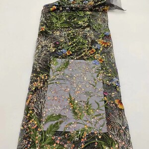 May include: Black mesh fabric with a floral pattern embroidered with sequins and beads. The flowers are in shades of orange, yellow, green, and blue.