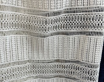 May include: White crochet fabric with a repeating pattern of small circles and rows of small white beads.