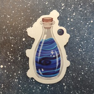 May include: A sticker featuring a potion bottle with a cork stopper. The bottle contains swirling blue liquid with white star accents. The sticker has a white border and is set against a dark blue speckled background.
