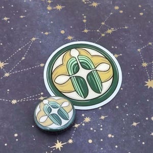 May include: Two circular stickers featuring a botanical design. The larger sticker has a white border and a green and yellow design. The smaller sticker is a button with the same design. The background is dark blue with gold constellation patterns.