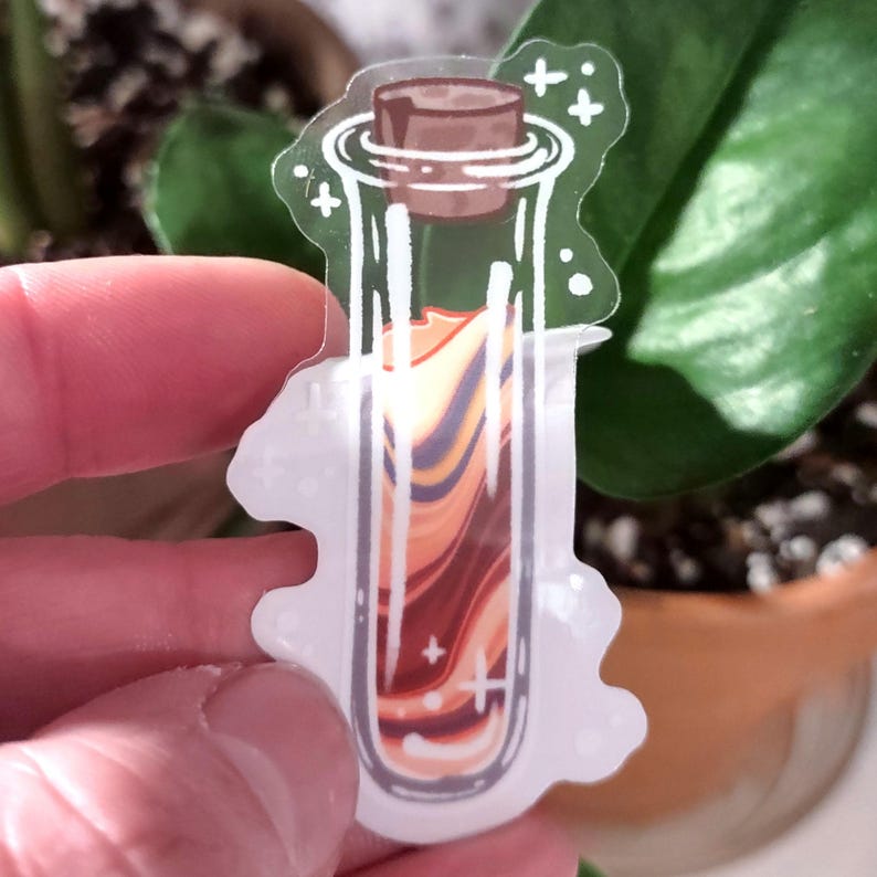 May include: A clear sticker featuring a potion bottle with a cork. The bottle contains layered orange, brown, and purple liquid. White accents and a white outline surround the bottle, with a few small crosses.