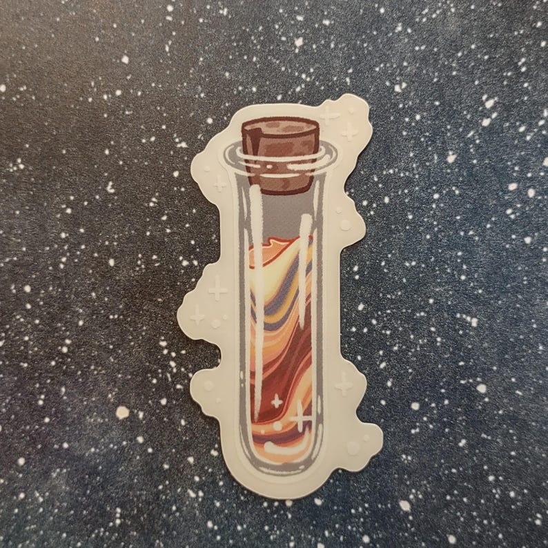 May include: A sticker featuring a glass vial with a cork stopper. The vial contains a swirling mixture of orange, yellow, and purple colors. The sticker has a white border with small cross-shaped designs.