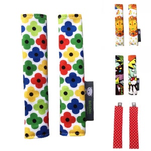 May include: Two pairs of colorful fabric stroller bar covers. One pair features a red, yellow, green, and blue floral pattern. The other pair features a red and white polka dot pattern. The covers are made by BellaCushi Designs.