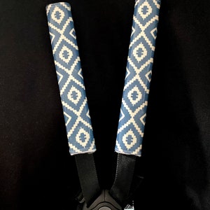 May include: Two blue and white patterned stroller strap covers with the text "NAZCA INDIAN BLUE" on a black background.