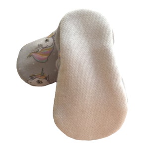 May include: A pair of gray baby booties with a unicorn print. The booties have a white sole.