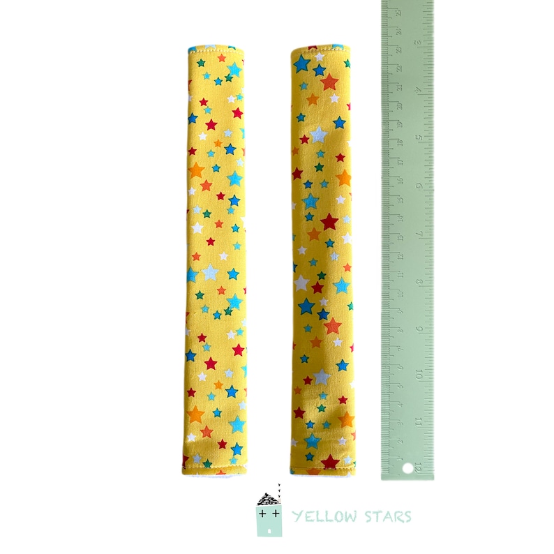 May include: Two yellow fabric covered handles with a multi-colored star pattern. The handles are approximately 12 inches long.  The text "YELLOW STARS" is printed below the handles.