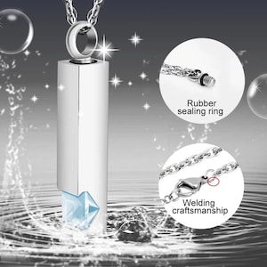 May include: Silver pendant necklace with a clear crystal and a silver chain. The pendant is a cylinder with a screw-on top and a rubber sealing ring. The chain has a welded clasp.
