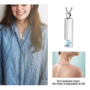 May include: A silver necklace with a rectangular pendant that has a small blue crystal. The chain is adjustable with a 5 cm extender chain.