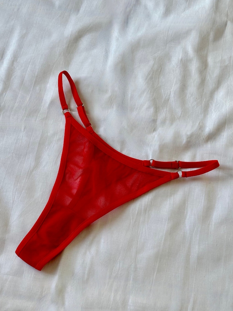 May include: Red mesh lingerie with adjustable straps and silver rings.