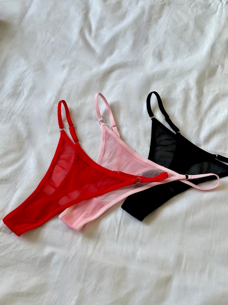 May include: Three pairs of sheer lingerie in red, pink, and black. The lingerie is made of a delicate mesh fabric and has adjustable straps.