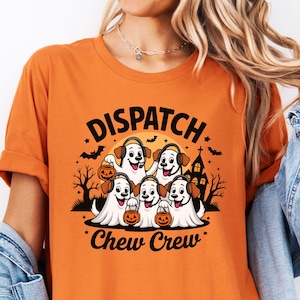 May include: Orange t-shirt with the words "Dispatch Chew Crew" in black. The graphic features cartoon dogs dressed as ghosts holding jack-o'-lanterns. A spooky Halloween design with bats, a haunted house, and a full moon.