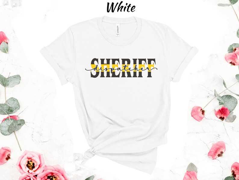 May include: White t-shirt with black text that reads "SHERIFF dispatcher" with a yellow stripe above the text.