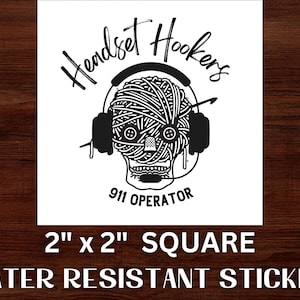 May include: Black and white sticker of a skull wearing headphones with yarn in its head. The text "Handset Hookers 911 Operator" is below the skull. The sticker is 2 inches by 2 inches square and water resistant.
