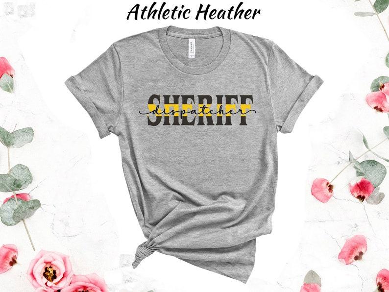 May include: Gray t-shirt with the text "SHERIFF dispatcher" in black lettering with a yellow stripe above the text.
