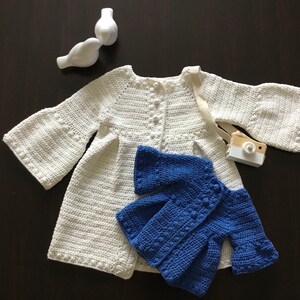 May include: Two crocheted cardigans, one white and one blue. The white cardigan has bell sleeves and a button closure. The blue cardigan has a similar style with a slightly shorter length.