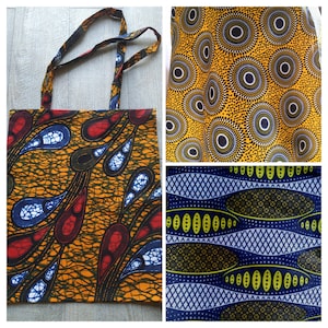 Peut inclure: Un sac fourre-tout réutilisable en tissu avec un motif imprimé africain coloré. Le sac a un motif jaune, orange, rouge, bleu et blanc avec des formes de gouttes.