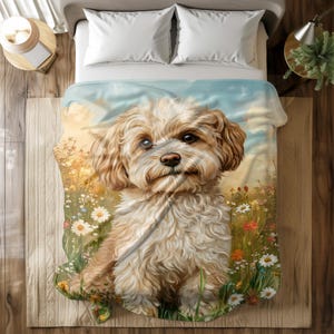 Peut inclure: Une couverture douce et moelleuse représentant un adorable chien crémeux et duveteux aux yeux bruns assis dans un champ de fleurs sauvages colorées. Le chien regarde directement le spectateur.