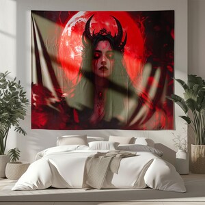 Peut inclure: Une grande tapisserie repr&eacute;sentant une illustration gothique d'une femme avec des cornes noires, une couronne et des yeux rouges. L'arri&egrave;re-plan comprend une lune rouge et des figures sombres et ombrag&eacute;es. L'&oelig;uvre est principalement rouge et noire.