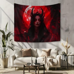 Peut inclure: Une tapisserie rouge et noire repr&eacute;sentant une figure d&eacute;moniaque avec des cornes et une couronne, sur fond de lune rouge. L'&oelig;uvre d'art a un th&egrave;me gothique, avec de longs cheveux noirs et des yeux rouges. La tapisserie est accroch&eacute;e au-dessus d'un canap&eacute; blanc.