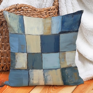 May include: A blue and beige throw pillow with a geometric pattern. The pillow is made of a soft, comfortable fabric and has a zipper closure.