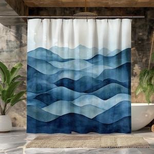 Könnte beinhalten: Duschvorhang mit einem Wasserfarben-Motiv von blauen Bergen auf weißem Hintergrund. Die Berge sind übereinander geschichtet und haben einen weichen, abstrakten Look.