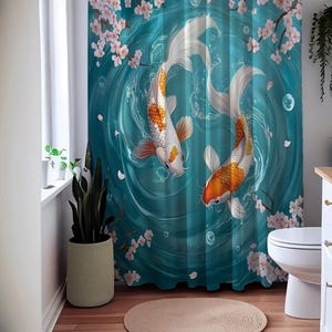 Puede incluir: Una cortina de ducha azul verdosa con un dise&ntilde;o de dos peces koi naranja y blanco nadando en un c&iacute;rculo de agua con flores de cerezo rosas.