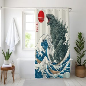 May include: Shower curtain featuring a Godzilla design in the style of a Japanese woodblock print. The artwork depicts Godzilla emerging from a large ocean wave, with a red sun and Japanese text in the background.