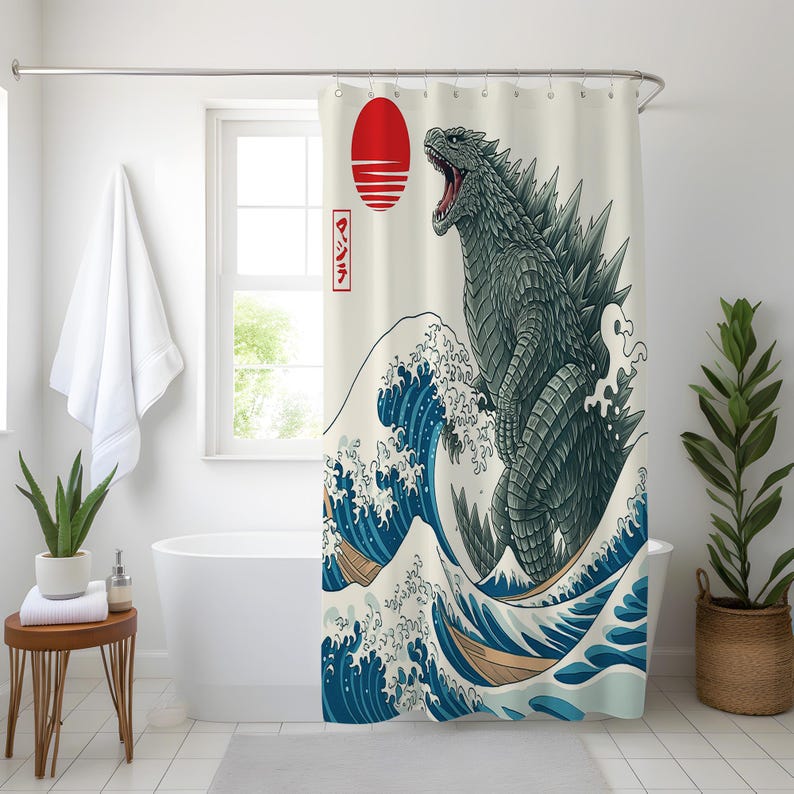 May include: Shower curtain featuring a Godzilla design in the style of a Japanese woodblock print. The artwork depicts Godzilla emerging from a large ocean wave, with a red sun and Japanese text in the background.
