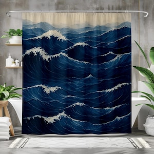 May include: A blue and white shower curtain featuring a watercolor painting of ocean waves. The waves are depicted in varying shades of blue with white crests, creating a dynamic and artistic design. The curtain hangs from a silver rod.