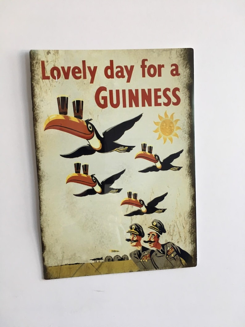 Puede incluir: Un letrero de estilo vintage con el texto "Lovely day for a Guinness". La imagen presenta tucanes de dibujos animados que llevan pintas de Guinness, un sol y dos hombres con uniformes militares. El letrero tiene un aspecto envejecido.