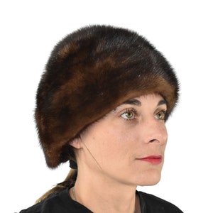 May include: A brown fur hat with a wide brim. The hat is made of soft, luxurious fur and has a classic, elegant style.