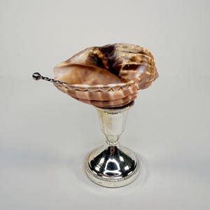 Könnte beinhalten: Ein Set aus drei Keramikbechern mit gesprenkelter, matter Oberfläche. Die Becher sind in Creme-, Hellgrau- und Dunkelgrautönen gehalten. Jeder Becher hat ein schlichtes, minimalistisches Design.