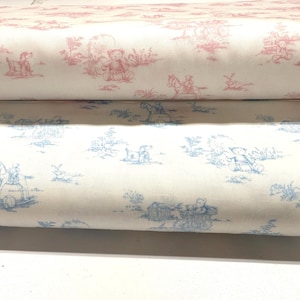 May include: Two rolls of fabric with a toile pattern. The top roll features a pink design with teddy bears and children on rocking horses. The bottom roll has a blue design with similar imagery. Both rolls are on a white background.