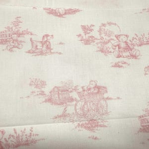 May include: White fabric with a repeating pattern of pink teddy bears, dogs, and other pastoral scenes. The design is reminiscent of a toile fabric, with a vintage or antique aesthetic. The fabric is likely cotton or linen.