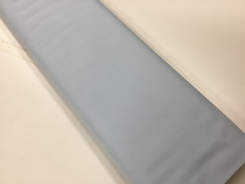 May include: A piece of light blue fabric. The fabric is smooth and has a subtle sheen.